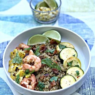 chipotle bacon, grilled shrimp and veggies over rice served in a white bowl