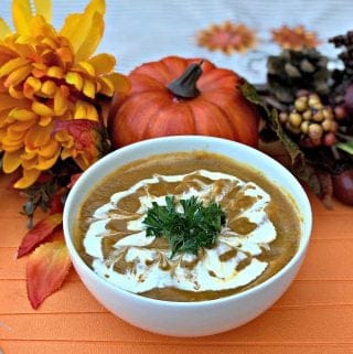 Instant Pot Pumpkin Spice and Sweet Potato Soup in a white bowl with fall decor in the background