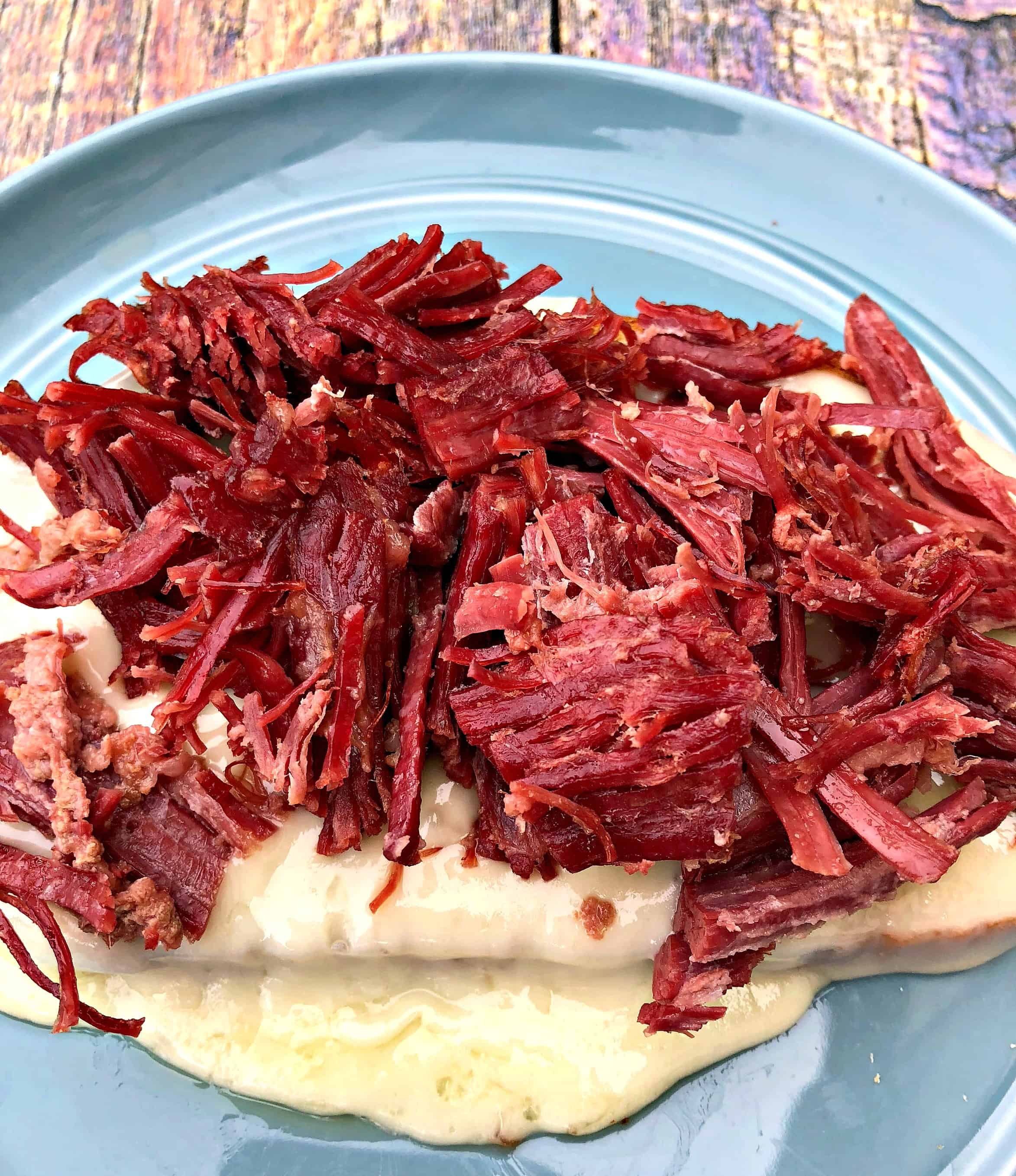 Instant Pot Corned Beef Reuben Sandwich with rye bread, sauerkraut, and thousand island dressing on a blue plate