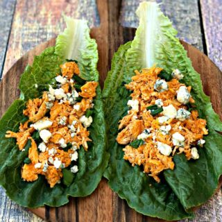 buffalo chicken wraps on romaine lettuce on a cutting board with blue cheese