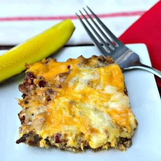 keto cheeseburger casserole with pickle on a white plate