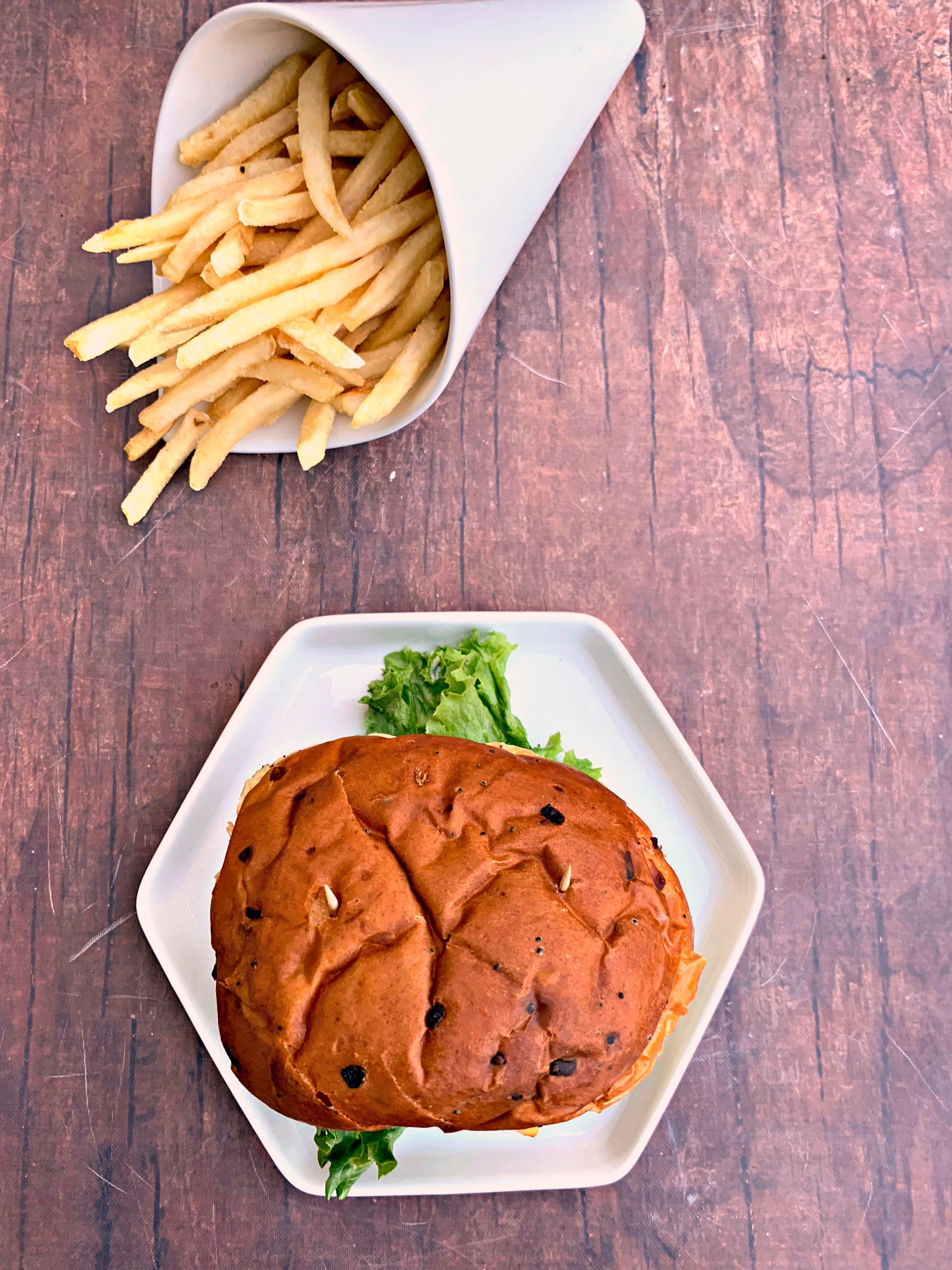 juicy air fryer cheeseburgers on a bun and white plate with fries