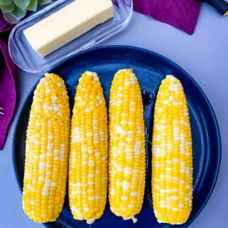 instant pot corn on the cob on a blue plate with a purple napkin