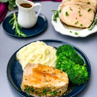 Instant Pot Pork Loin on a blue plate with cauliflower mash and broccoli