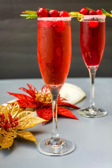 cranberry champagne mimosa in a glass with fresh cranberries