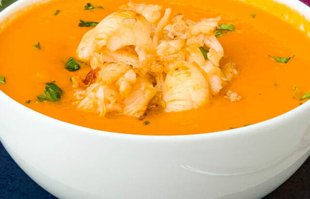 creamy homemade lobster bisque recipe in a white bowl with a purple towel