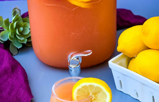 jungle juice cocktail recipe in a 2 gallon glass container with fresh fruit