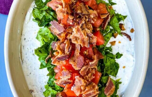 BLT dip with lettuce, bacon, and tomatoes in a serving dish