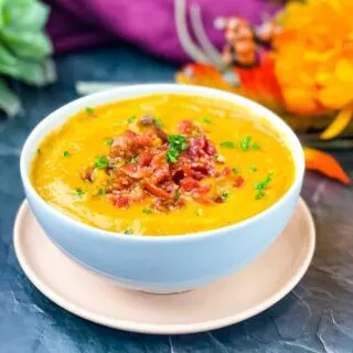 sweet potato soup in a white bowl with chunks of bacon