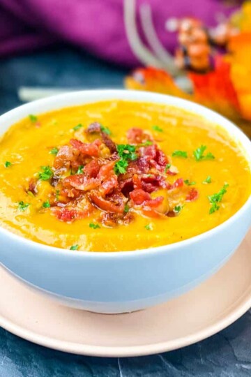 sweet potato soup in a white bowl with chunks of bacon