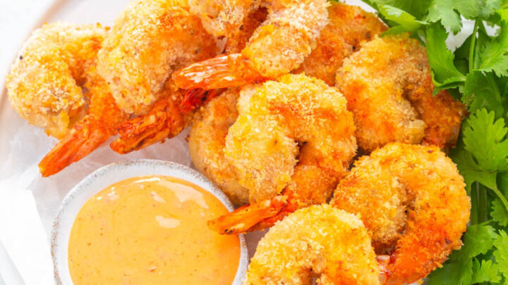 air fryer bang bang shrimp on a white plate with lettuce