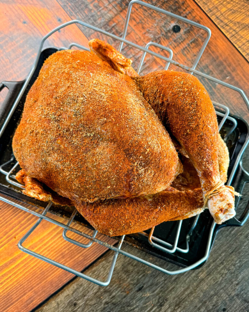 raw Cajun seasoned turkey on a roasting pan