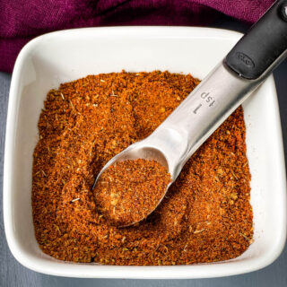 homemade chili seasoning in a white bowl with a spoon