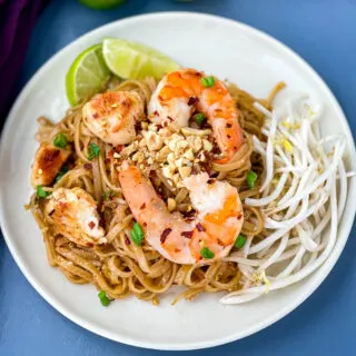 healthy pad thai with chicken, shrimp, bean sprouts, and lime on a white plate