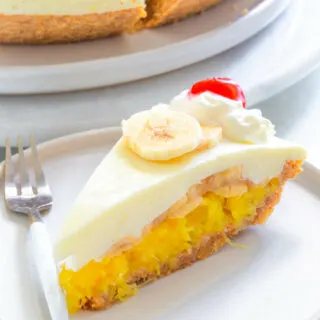 banana split pie on a plate with cherries and whipped cream