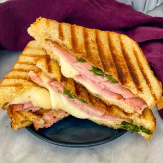 sliced ham and cheese panini sandwich on a plate