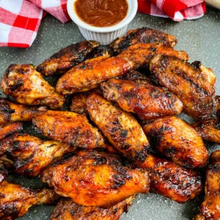 grilled chicken wings on a plate with BBQ sauce