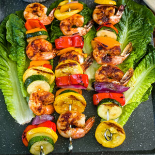 BBQ grilled shrimp skewers on a bed of lettuce