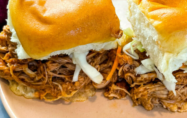 pulled pork sliders with coleslaw on a pink plate