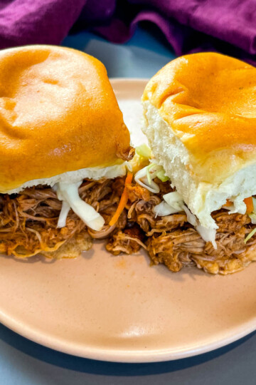 pulled pork sliders with coleslaw on a pink plate