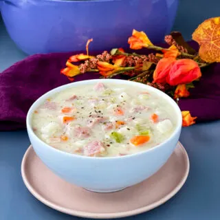 creamy ham, potato, and vegetable soup in a white bowl