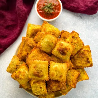 air fryer toasted fried ravioli on a plate with marinara sauce