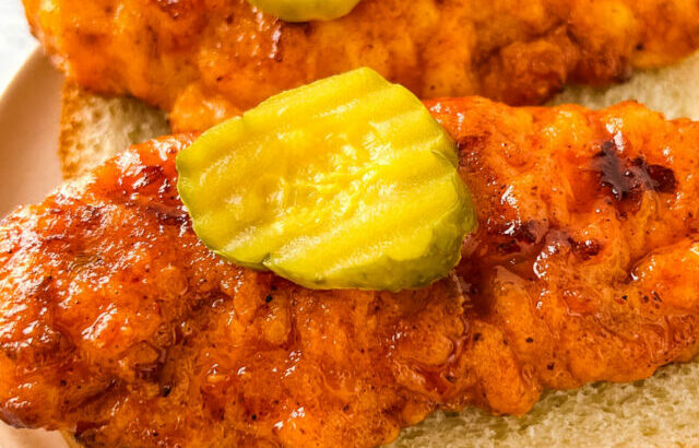 Nashville hot chicken tenders on bread with pickles