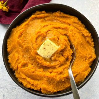 mashed sweet potatoes in a bowl with butter and brown sugar