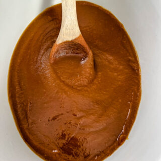 sugar free apple butter in a slow cooker with a wooden spoon