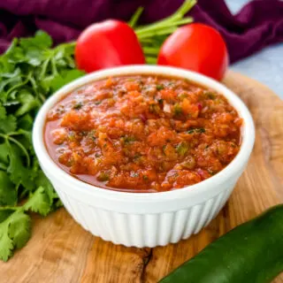 smoked salsa in a white bowl on a platter with fresh tomatoes, cilantro, and jalapeno