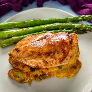 oven baked stuffed chicken breast on a plate with asparagus