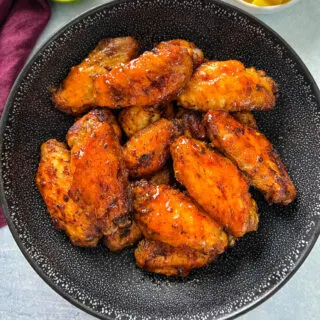 mango habanero wings in a black bowl