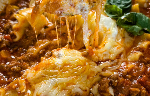 cheese pull of lasagna soup in a bowl