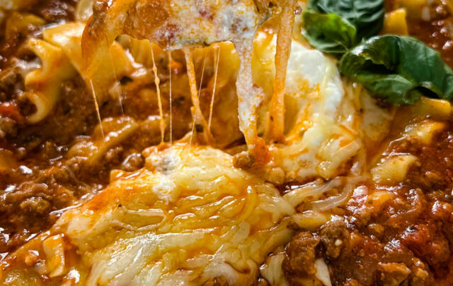 cheese pull of lasagna soup in a bowl