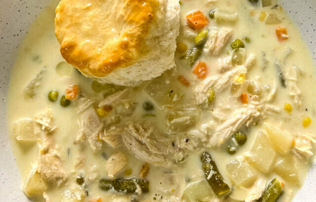 slow cooker crockpot chicken pot pie in a bowl with a biscuit