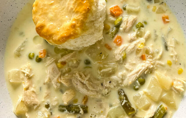 slow cooker crockpot chicken pot pie in a bowl with a biscuit