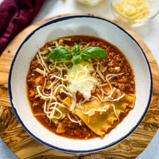 beef lasagna soup with basil and cheese in a bowl