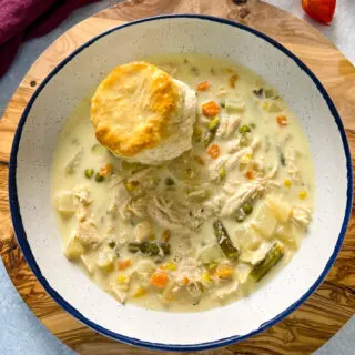 slow cooker crockpot chicken pot pie in a bowl with a biscuit