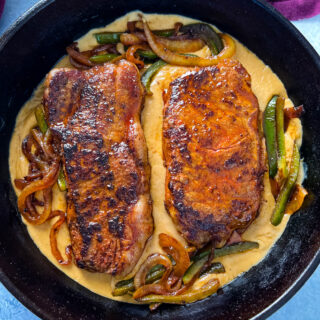 smothered steak with gravy in a cast iron skillet