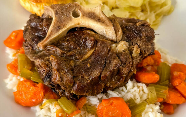 beef neck bones with cabbage, rice, and carrots on a plate