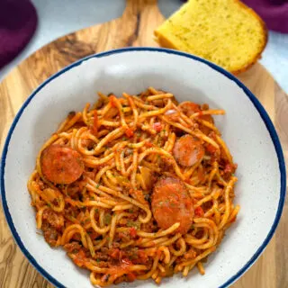 beef and sausage spaghetti in a white bowl