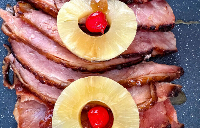 slow cooker crockpot ham on a plate with pineapples and glaze