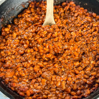 smoked baked beans with ground beef and bacon in a cast iron skillet