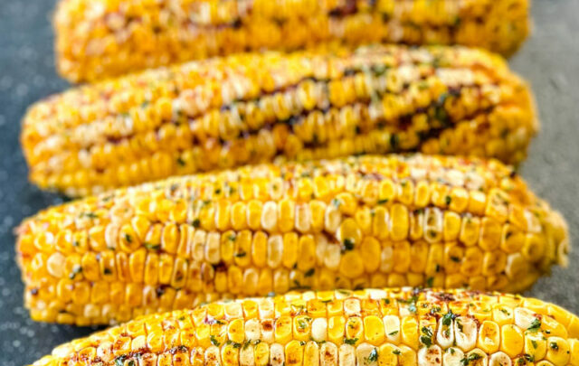 Traeger smoked corn on the cob with garlic butter on a sheet pan