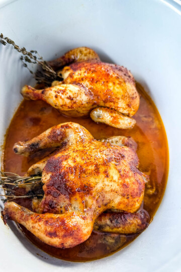 cornish hens in a Crockpot slow cooker with broth and herbs