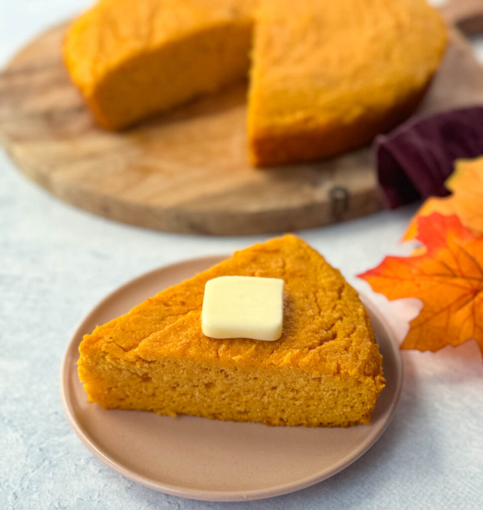 a slice of sweet potato cornbread with butter on a plate