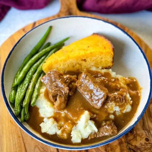 beef tips and gravy with green beans and cornbread in a bowl