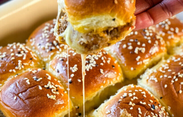 person holding Kings Hawaiian Sliders with cheese