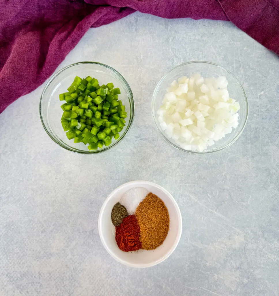 diced onions, diced bell peppers, and spices in separate bowls