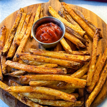 Cajun fries on a platter with ketchup